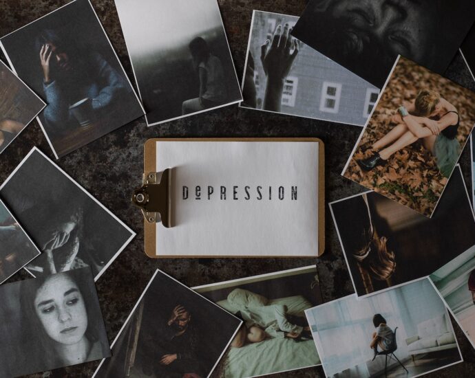 A clipboard with a paper that says depression sits among seasonal depression images.
